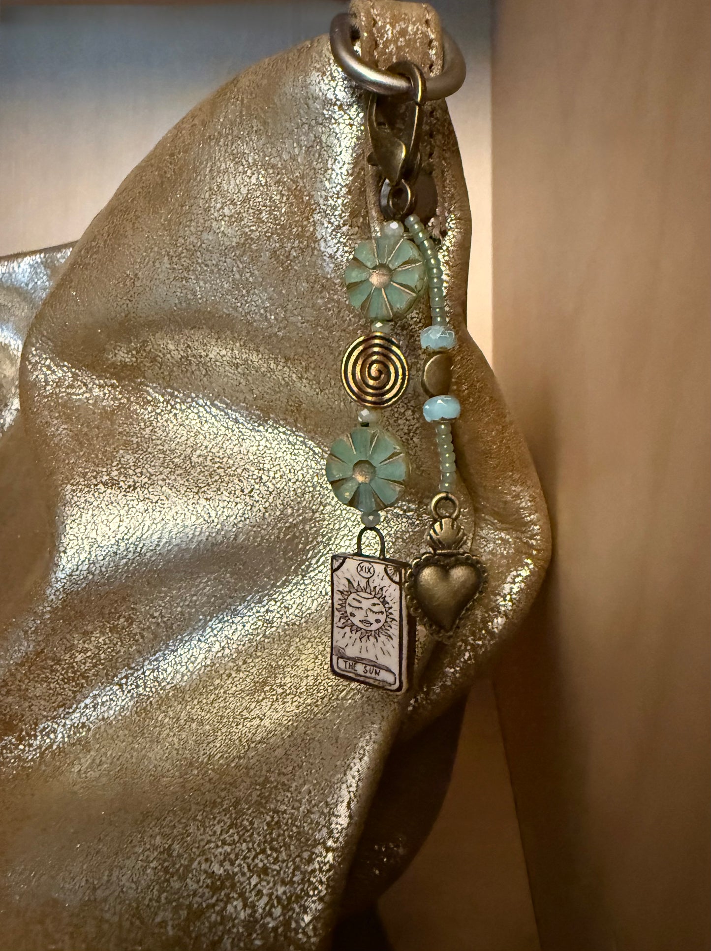 One-of-a-kind, handmade bag charm with two jeweled strands in tones of bronze and green.