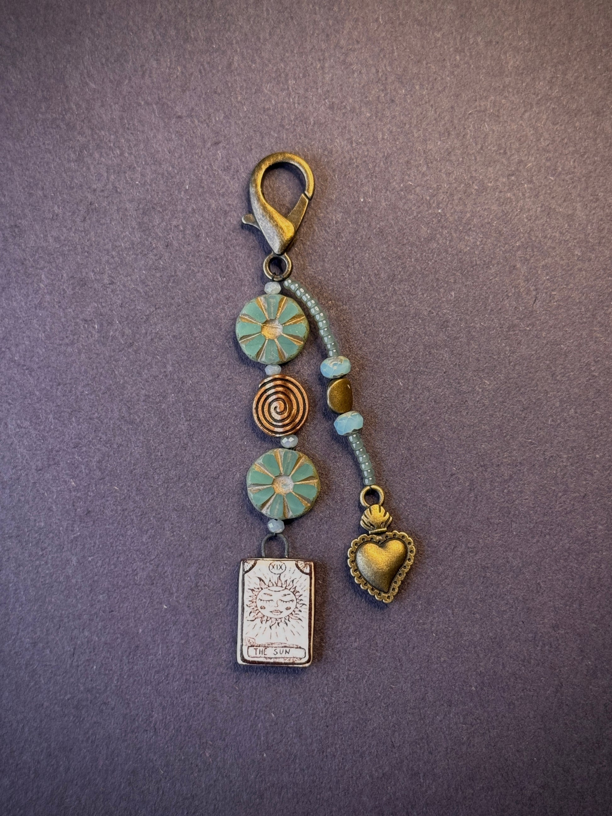 One-of-a-kind, handmade bag charm with two jeweled strands in tones of bronze and green.