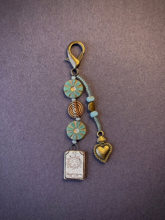 One-of-a-kind, handmade bag charm with two jeweled strands in tones of bronze and green.